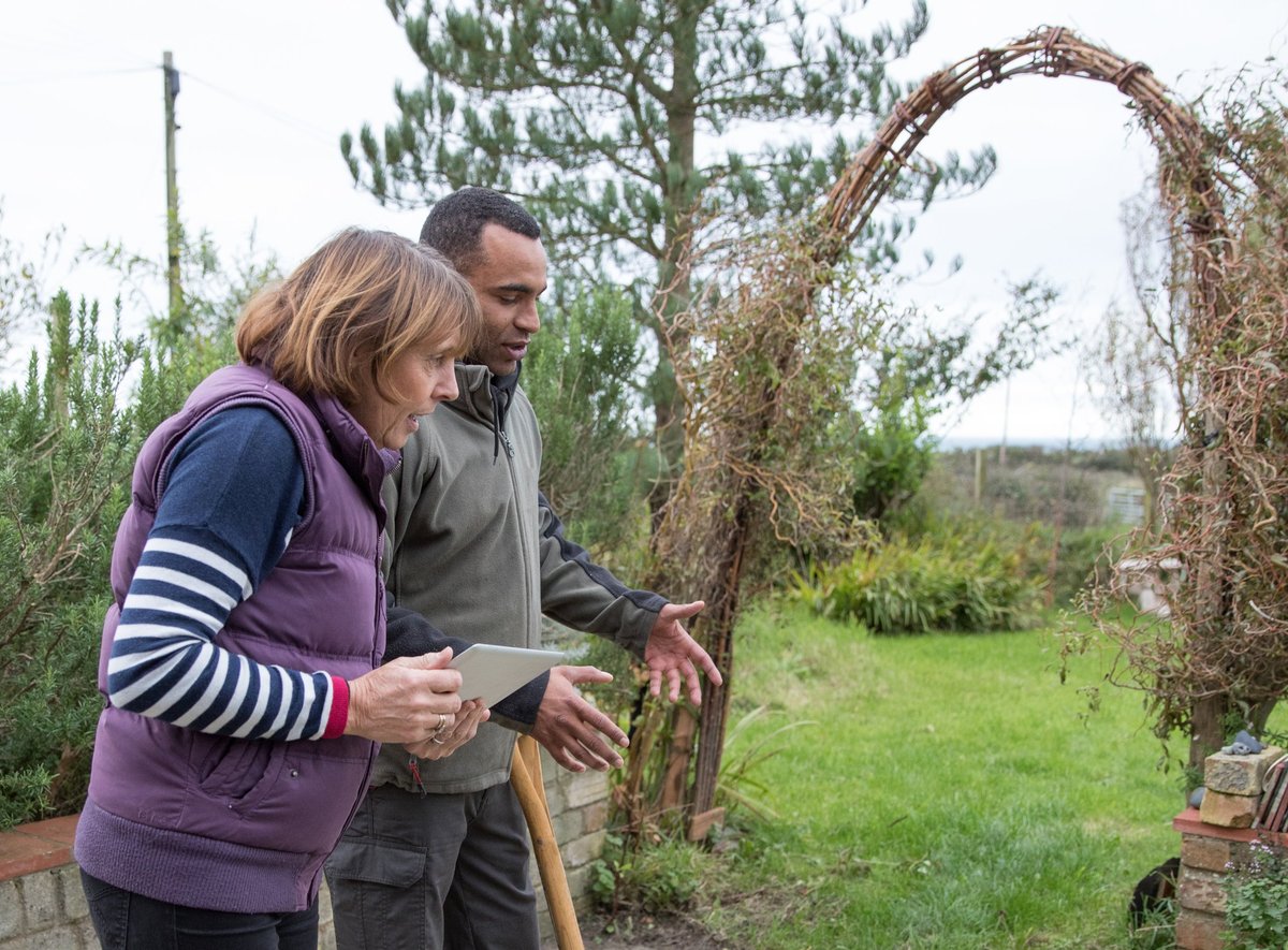 Landscape gardener advising a customer regarding her garden plot