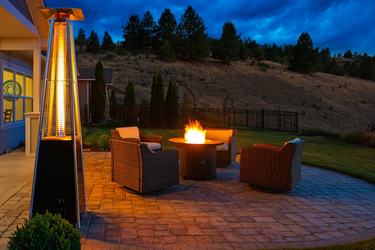 Pyramid patio heater and flaming fire pit warming a residential outdoor deck with seating